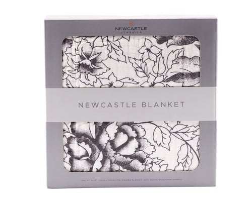 Couverture bébé Mousseline blanche en bambou, ornée d’un motif floral noir, pliée dans son coffret Newcastle