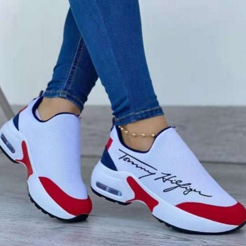 Sneakers Plates Casual Respirantes blanches en maille, sans lacets, avec accents rouges et bleu marine et semelle épaisse.